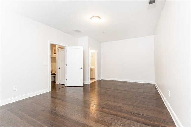 empty room featuring visible vents, baseboards, and wood finished floors