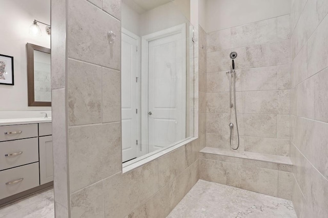 bathroom with vanity and tiled shower