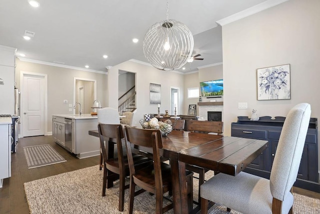 dining area featuring crown molding, dark hardwood / wood-style flooring, a chandelier, and sink