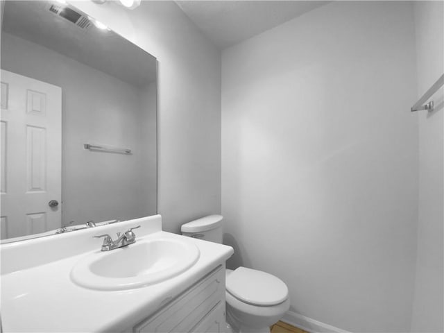 bathroom featuring visible vents, vanity, and toilet