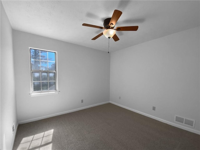 unfurnished room with ceiling fan, carpet flooring, visible vents, and baseboards