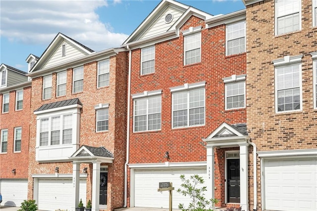 townhome / multi-family property featuring a garage, driveway, and brick siding