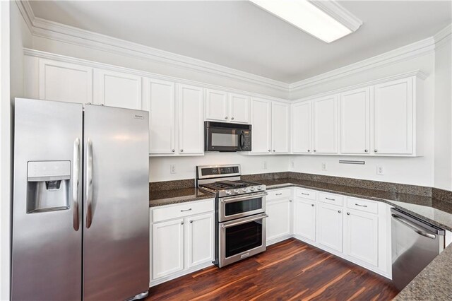 kitchen with dark stone counters, white cabinetry, dark wood-style floors, and stainless steel appliances