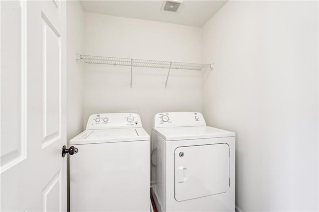 washroom featuring washing machine and clothes dryer, laundry area, and visible vents