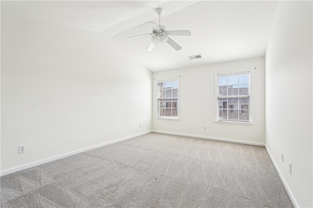 unfurnished room with visible vents, a ceiling fan, baseboards, lofted ceiling with beams, and carpet flooring