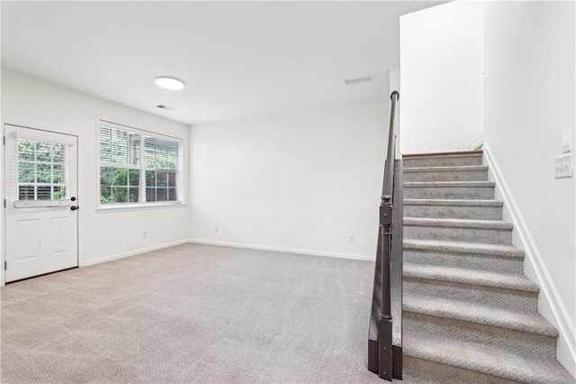 staircase featuring carpet flooring, baseboards, and visible vents