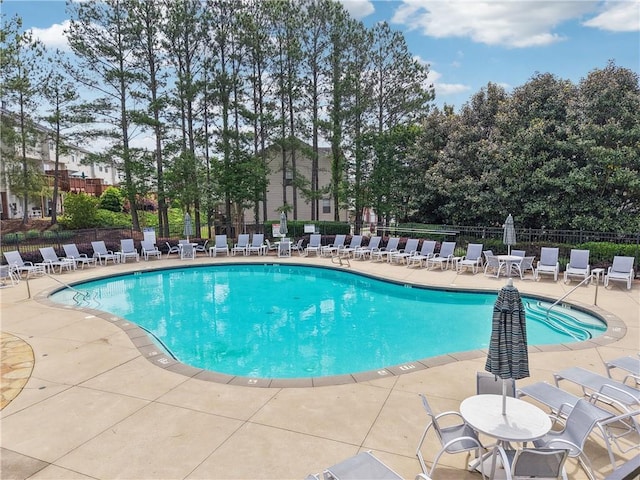 pool with fence and a patio area