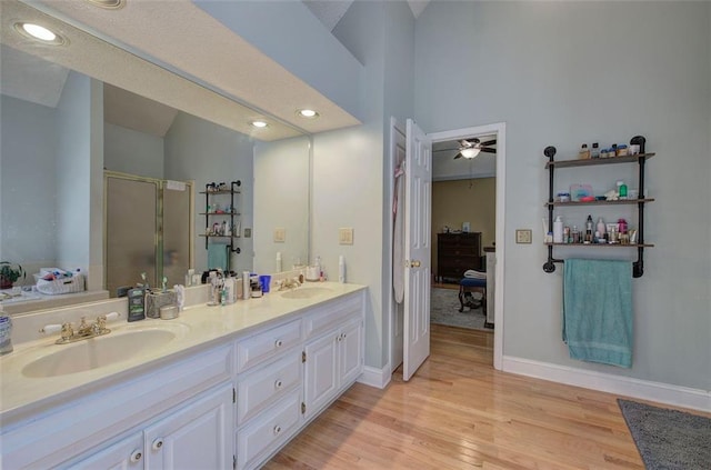 bathroom with walk in shower, hardwood / wood-style floors, vanity, and ceiling fan