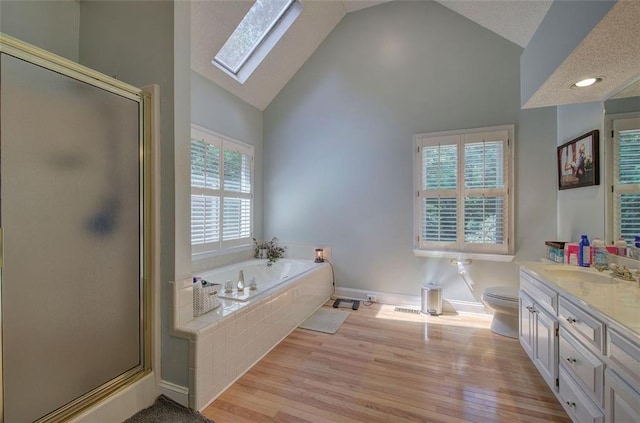 full bathroom featuring plus walk in shower, high vaulted ceiling, hardwood / wood-style floors, toilet, and vanity