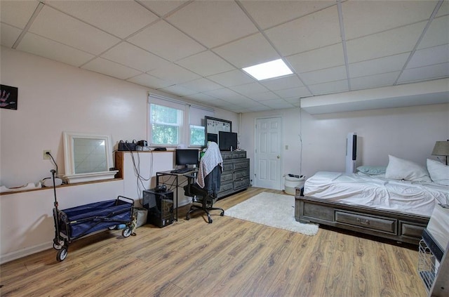 bedroom featuring a paneled ceiling and light hardwood / wood-style flooring