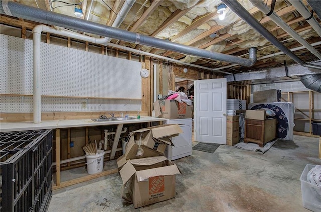 basement featuring a workshop area, washer / clothes dryer, and sink