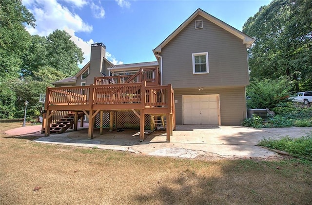 back of house with a yard, a garage, and a deck