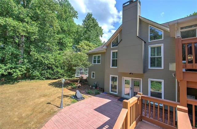 back of property featuring a yard and french doors