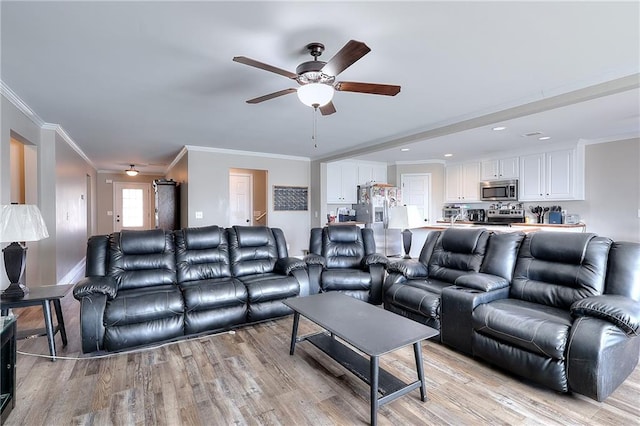 living room featuring crown molding, light wood-type flooring, and ceiling fan