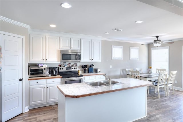 kitchen featuring stainless steel appliances, sink, light wood-type flooring, and white cabinets