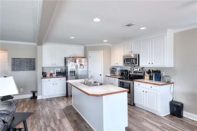 kitchen featuring appliances with stainless steel finishes, an island with sink, hardwood / wood-style floors, and white cabinets