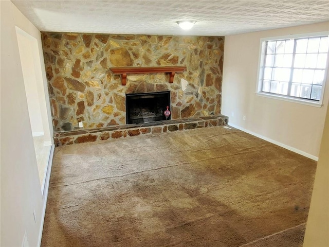 unfurnished living room featuring a fireplace, a textured ceiling, and carpet