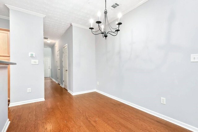 786 Brookside Parc Ln, Avondale Estates, GA 30002 - unfurnished dining area featuring wood finished floors, a chandelier, and crown molding