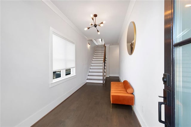 interior space featuring baseboards, stairway, ornamental molding, wood finished floors, and a notable chandelier