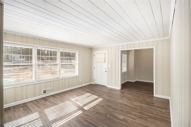 unfurnished room featuring dark wood-type flooring and wooden ceiling