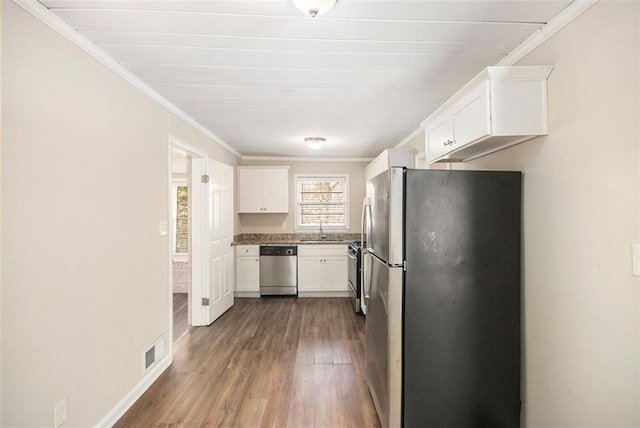 kitchen featuring dark wood-type flooring, appliances with stainless steel finishes, crown molding, and white cabinetry