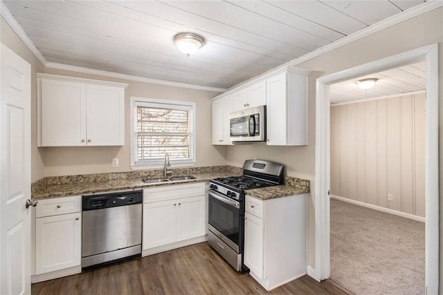 kitchen featuring dark colored carpet, stainless steel appliances, dark stone countertops, white cabinets, and sink