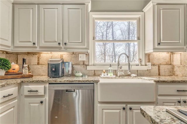 kitchen with tasteful backsplash, a sink, white cabinetry, and stainless steel dishwasher