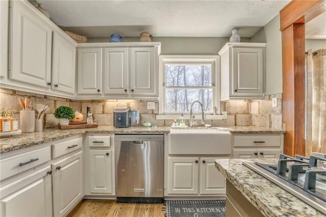285 Skeet Shoot Rd, Dallas, GA 30132 - kitchen with appliances with stainless steel finishes, a sink, white cabinets, light wood-type flooring, and backsplash