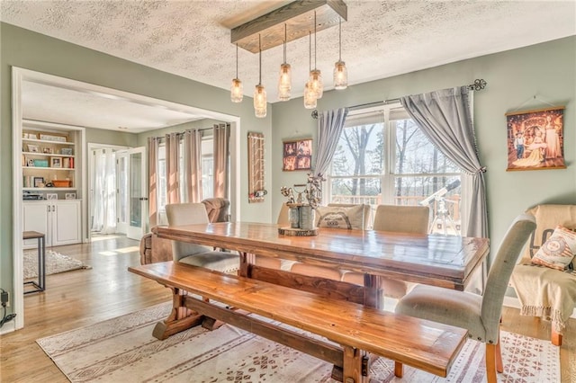 dining room with light wood-style floors and a textured ceiling