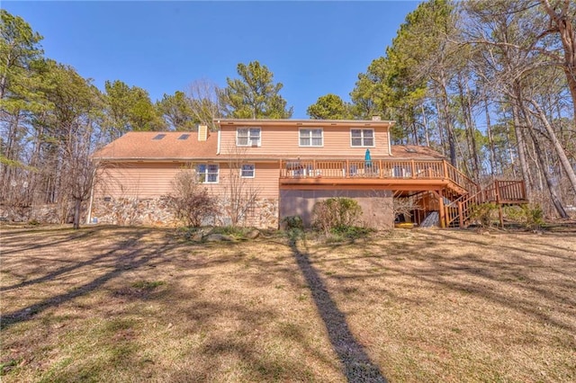 rear view of property with stairway, a lawn, and a wooden deck