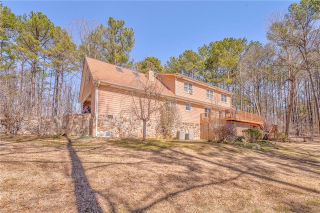 rear view of property with crawl space, cooling unit, a yard, and a deck