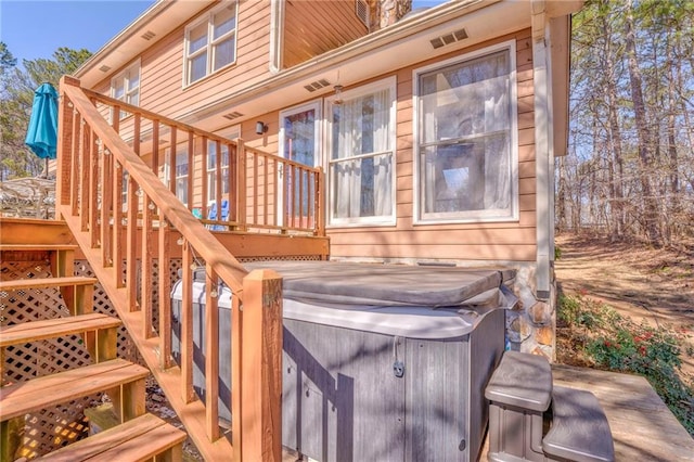 deck with stairway, visible vents, and a hot tub