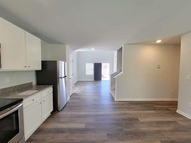 kitchen with white cabinets, dark hardwood / wood-style flooring, dark stone countertops, and appliances with stainless steel finishes