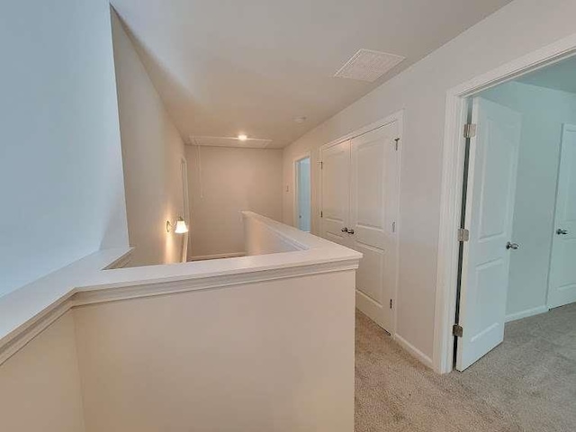 hallway featuring light colored carpet