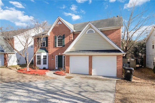 view of front of property featuring brick siding, driveway, and an attached garage