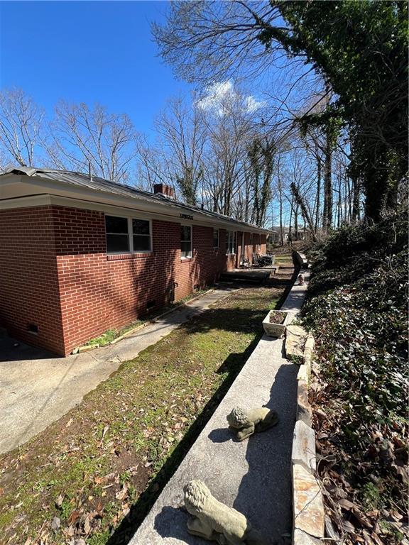 view of side of property featuring crawl space and brick siding