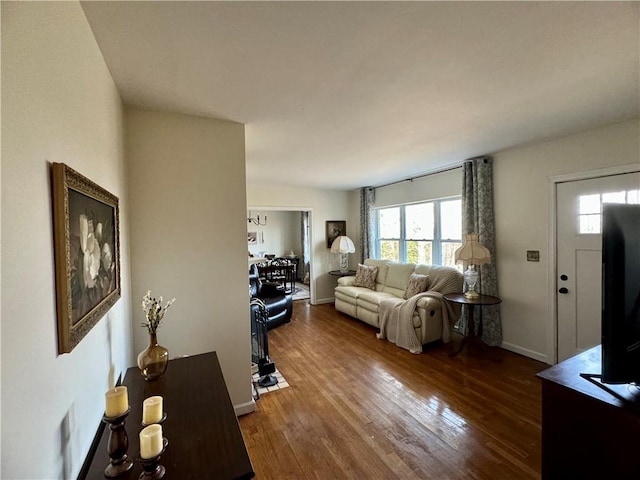 living area with baseboards and dark wood finished floors