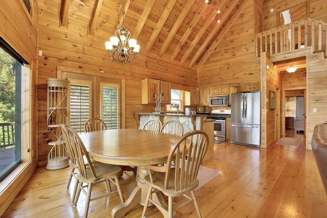 71 Hidden Valley Dr S, Ellijay, GA 30536 - dining space with high vaulted ceiling, healthy amount of natural light, wood walls, a chandelier, and light wood-type flooring