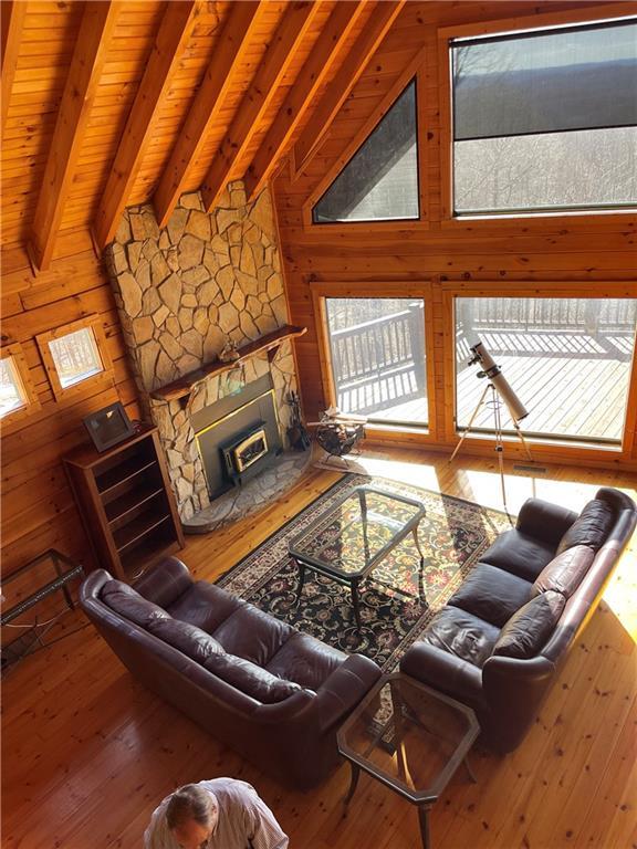 71 Hidden Valley Dr S, Ellijay, GA 30536 - living room with a stone fireplace, wood walls, and hardwood / wood-style flooring
