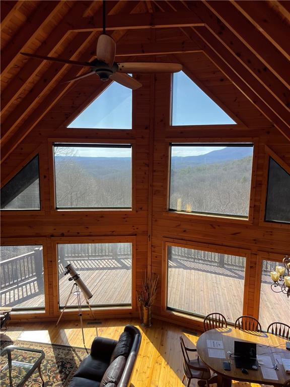 71 Hidden Valley Dr S, Ellijay, GA 30536 - living area with wood walls, ceiling fan, hardwood / wood-style floors, and high vaulted ceiling