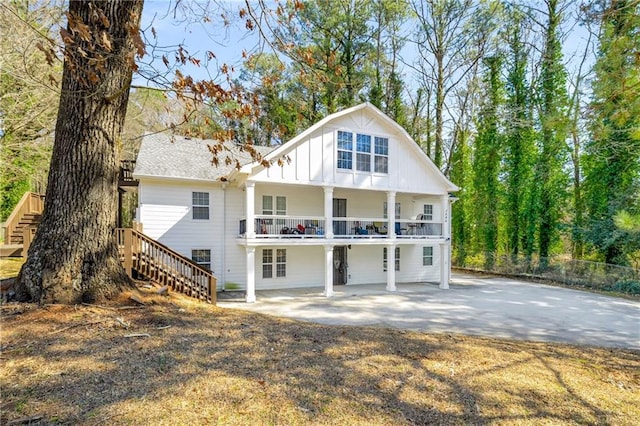 back of house featuring a patio area, stairway, fence, and board and batten siding