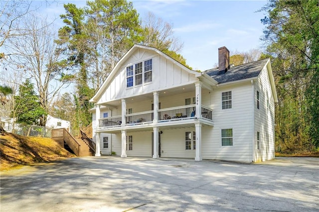 back of house featuring board and batten siding and a chimney