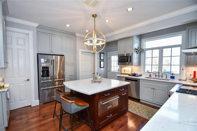 kitchen featuring light stone countertops, sink, appliances with stainless steel finishes, dark hardwood / wood-style floors, and pendant lighting