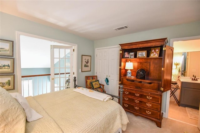 bedroom with sink, light carpet, and a closet