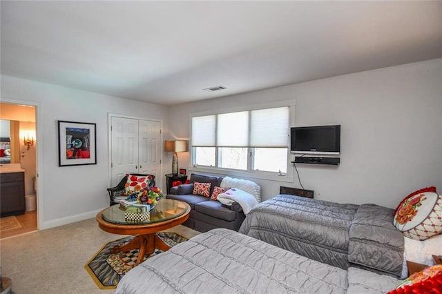 carpeted bedroom featuring connected bathroom and a closet