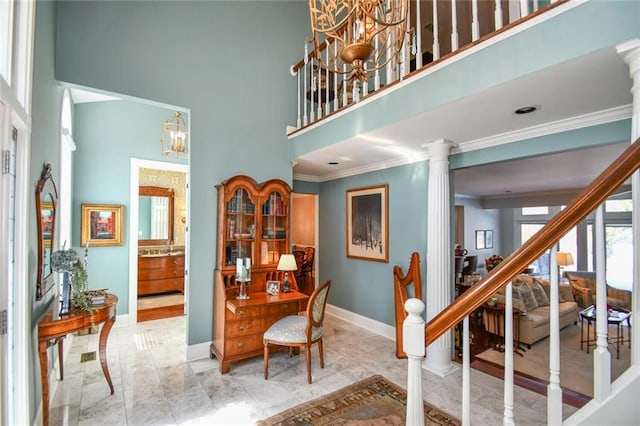 interior space featuring a notable chandelier, ornate columns, crown molding, and a towering ceiling