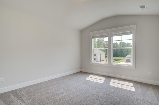 carpeted spare room with lofted ceiling