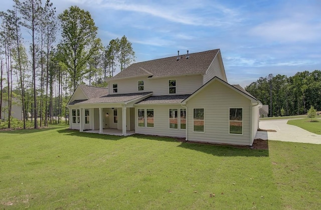 rear view of house with a yard and a patio