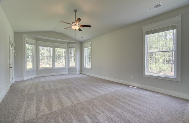 unfurnished room with light carpet, vaulted ceiling, plenty of natural light, and ceiling fan