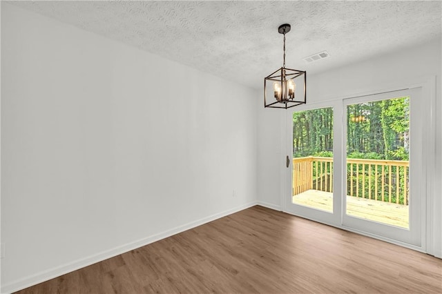 1645 Cobbs Creek Ln, Decatur, GA 30032 - unfurnished dining area with wood finished floors, a chandelier, baseboards, and a textured ceiling